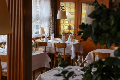 ein Esszimmer mit weißen Tischen und Stühlen sowie einem Fenster in der Unterkunft Hotel Kreuz in Malters