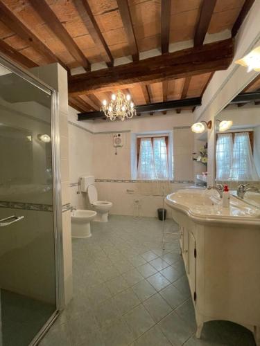 y baño con 2 lavabos, ducha y aseo. en Intero Appartamento con Private Pool e Jacuzzi Podere Settefrati, en Montaione