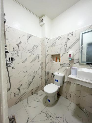 a white bathroom with a toilet and a sink at L'Appartement Harmonia Cozy in Casablanca