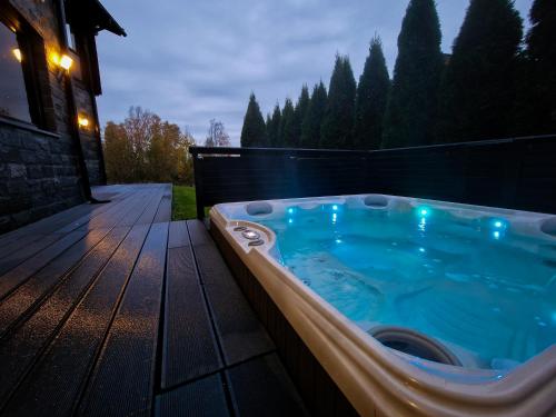 a jacuzzi tub sitting on a wooden deck at Villa Nevada - 10+2 henkilölle, Luoteis-Himos Ski-in/out, 255m² in Jämsä