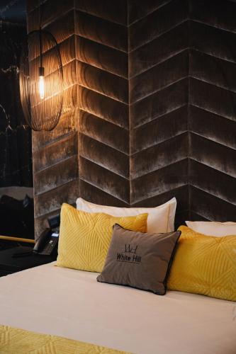a bed with a pillow that says the where inn at White Hill Hotel, SPA & Conferences in Durrës