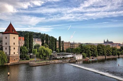 un fiume con un edificio accanto a un castello di Riverside Apartment a Praga