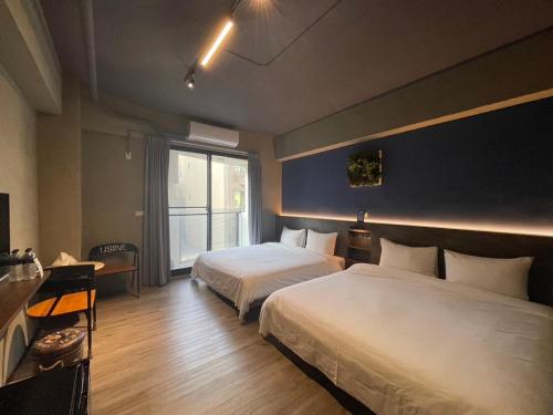 una camera d'albergo con due letti e una finestra di Long Lang Homestay a Tainan