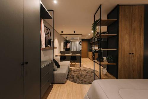 a bedroom with a bed and a desk in a room at Loft perfeito no Parque Una com garagem in Pelotas