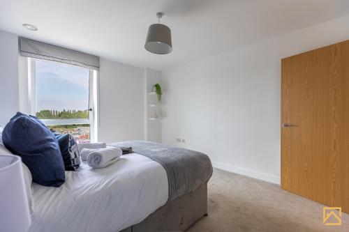 um quarto com uma cama e uma grande janela em Cosy 1 bed near peaceful canal By Valore Property Services em Milton Keynes