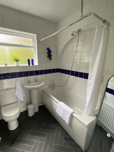 a bathroom with a tub and a toilet and a sink at The Old Postie Bed & Breakfast in Annesley