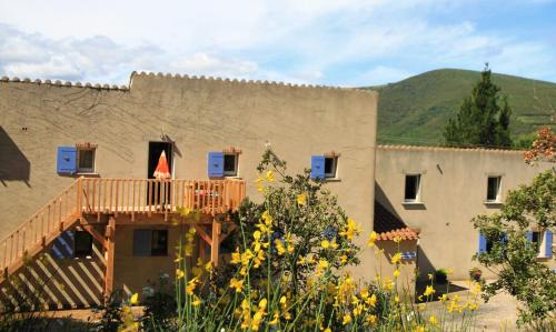 a building with a deck on the side of it at Gites-Terroirs-Occitanie in Felluns