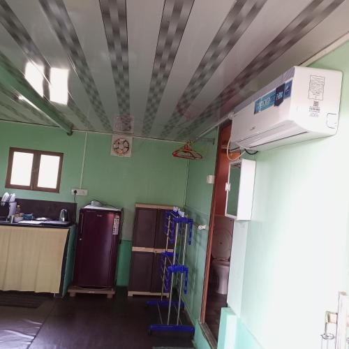a kitchen with green walls and a ceiling at Swastik Ac Apartment in Mandrem