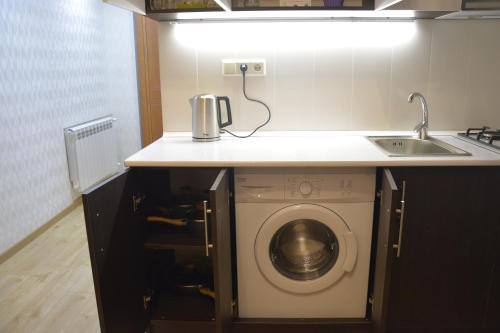a kitchen with a sink and a washing machine at Tovstonogovi Street Apartment in Tbilisi City