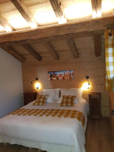 een slaapkamer met 2 bedden in een kamer met houten plafonds bij Aux fermes de la Croix, chambres, petits-déjeuners, diners in Hauteluce