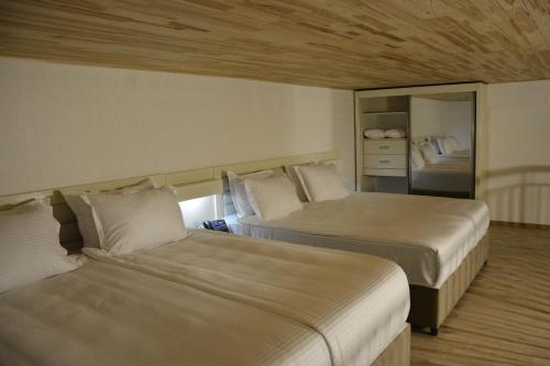 a bedroom with two beds and a mirror at Tovstonogovi Street Apartment in Tbilisi City
