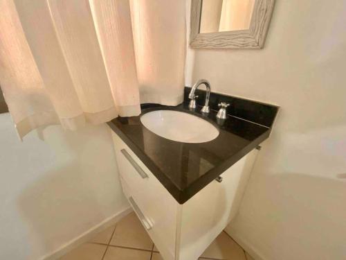 a bathroom with a sink and a bath tub at Ocean Flat 607 in Vila Velha