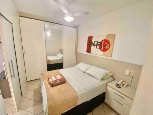 a small bedroom with a bed and a mirror at Ocean Flat 607 in Vila Velha