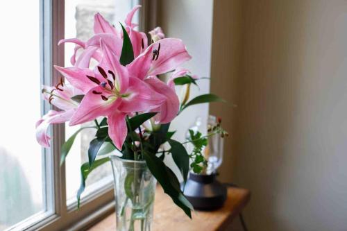 a vase of pink flowers sitting on a window sill at The Old Middle School Addingham in Addingham