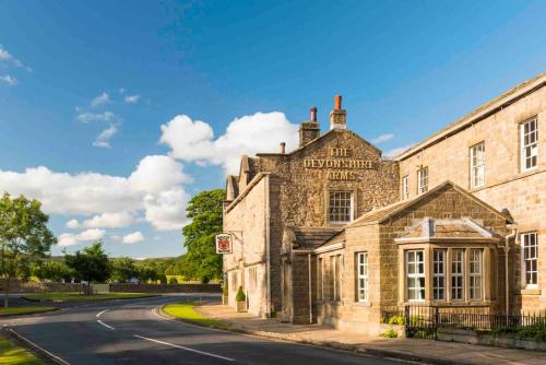 an old stone building on the side of a road at The Old Middle School Addingham in Addingham