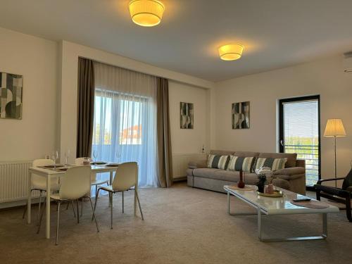 een woonkamer met een bank en een tafel bij Luxury Glam Apartments & Studios near Coresi Mall in Braşov