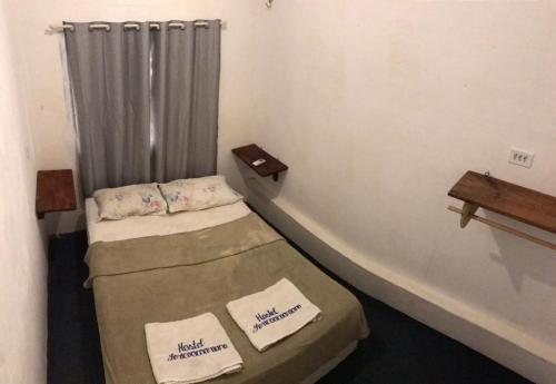 Habitación pequeña con 2 camas y cortina en Hostel Jericoacoariano, en Jericoacoara