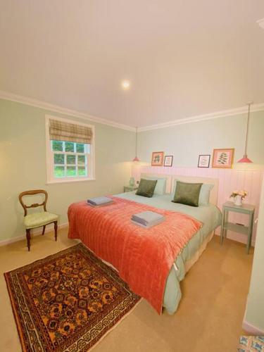 a bedroom with a large bed and a chair at River Cottage in Turriff
