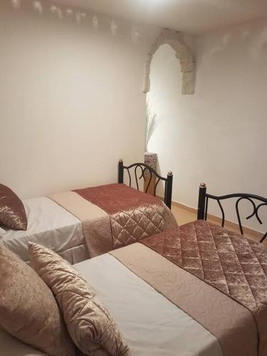 a room with two beds and an archway in it at Relaxed garden apartment with Galilee sea view 1 in Safed