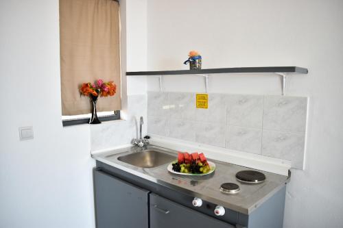 a small kitchen with a sink and a bowl of fruit at Oleander Studios in Faliraki