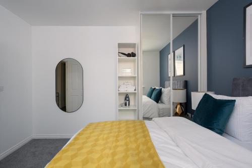 een slaapkamer met een groot bed en een spiegel bij Central 1-Bed perfect for you By Valore Property Services in Milton Keynes