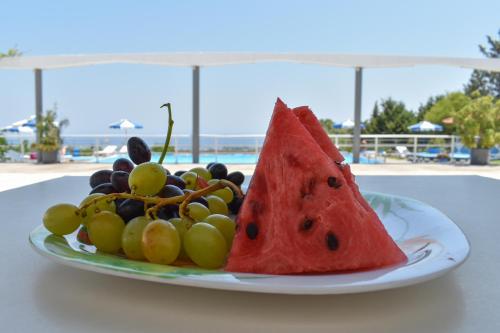 a plate of fruit on a table near the beach at Oleander Studios in Faliraki