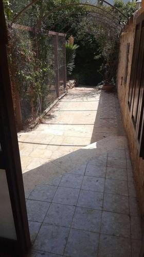 an alley way with a gate and a walkway at Relaxed garden apartment with Galilee sea view 1 in Safed