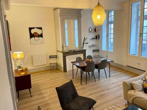 uma sala de estar com uma mesa e cadeiras e um sofá em 3 M en hyper centre em Montauban
