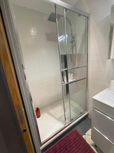 een douche met een glazen deur in de badkamer bij la Montagnette l oursson CHAMBRE in Moutiers
