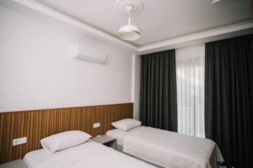 Cette chambre comprend 2 lits et une fenêtre. dans l'établissement Vira Villas Premium, à Göcek