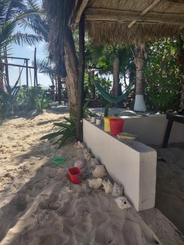 a sandy beach with a hammock on the beach at Lunazul Eco-Cabaña Frente al Mar in Mahahual