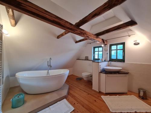 a bathroom with a large white tub and a sink at Unterkunft am Weinberg in Nünchritz