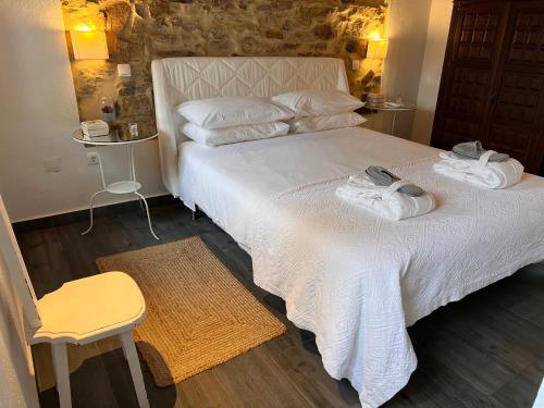 a bedroom with a bed with two towels on it at Casa Dos Galegos in Marvão