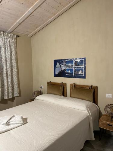 a bedroom with two beds and a painting on the wall at A Baracca du Pei in Imperia