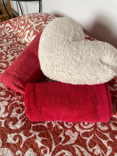 a pile of red and white towels on a bed at Casa Rural para descansar piscina cerca in Osor