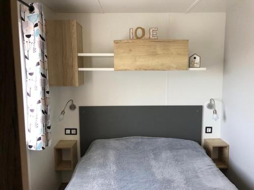 a bedroom with a bed and a wooden box above it at camping les sables du midi in Valras-Plage