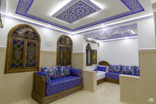 a living room with blue painted ceilings and purple furniture at Casa Sanae in Chefchaouene