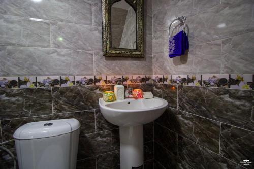 a bathroom with a sink and a mirror and a toilet at Casa Sanae in Chefchaouene