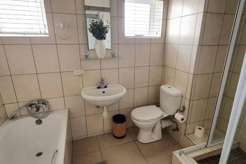 uma casa de banho com um WC, um lavatório e uma banheira em CUTTY SARK em Langstrand