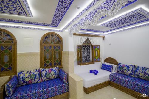 a room with blue and white ceilings and purple chairs at Casa Sanae in Chefchaouene