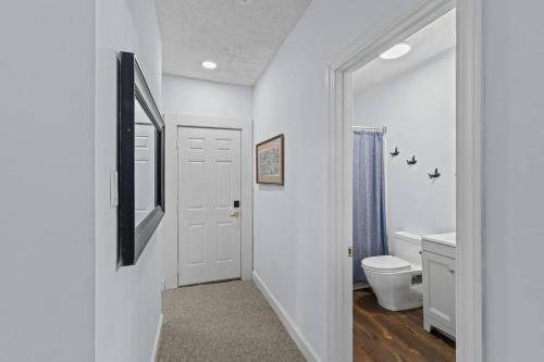 Baño blanco con aseo y espejo en Spaight House Suite en New Bern