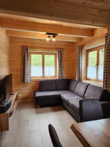 a living room with a couch and a television at Lipphütte Top Lage mit traumhafter Aussicht in Rauris