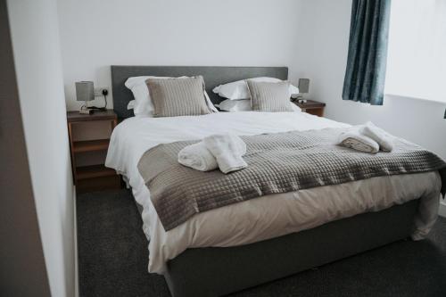 a bedroom with a large bed with towels on it at The Fox and Hounds in Banc-y-felin