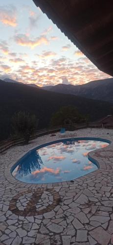 a pool of water on a patio with mountains in the background at Helmos Mountain Retreat in Zarouhla