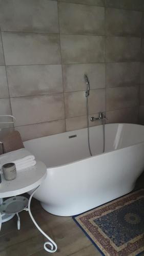 a white bath tub in a bathroom with a table at Pensjon Orzeł in Szczyrk