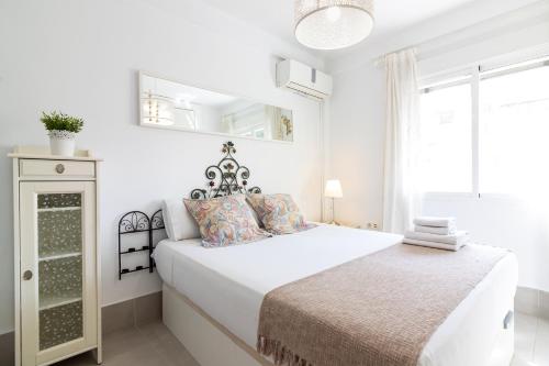 a white bedroom with a bed and a window at Malaga Center Flat Holidays Salitre in Málaga