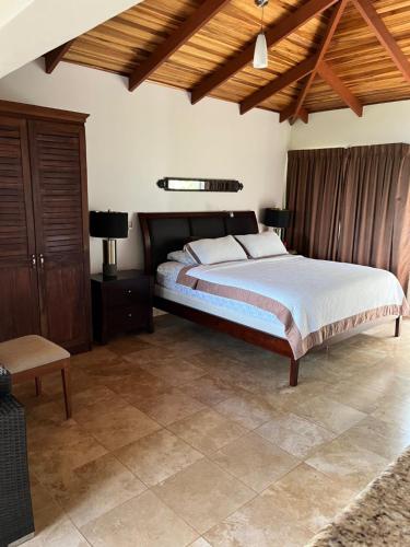 1 dormitorio con 1 cama grande y techo de madera en Ballena Bay Villa Lot 45 Villa del Mar, en Tambor