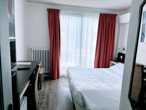 a bedroom with a bed and a window with red curtains at Brasilia Hôtel in Palavas-les-Flots