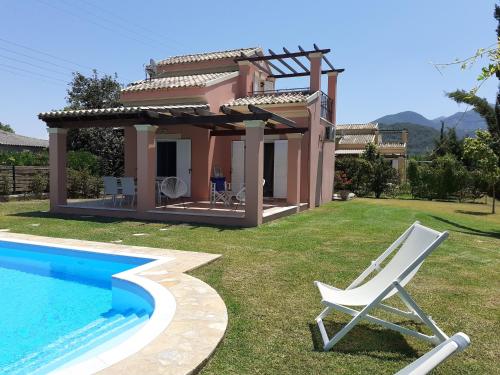 a villa with a pool and a chair next to a house at Villa Filia in Almiros Beach