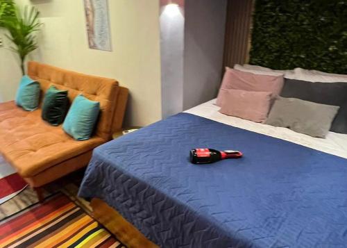 Un dormitorio con una cama azul con un coche rojo. en Minicasa Brasileira, en Sorocaba